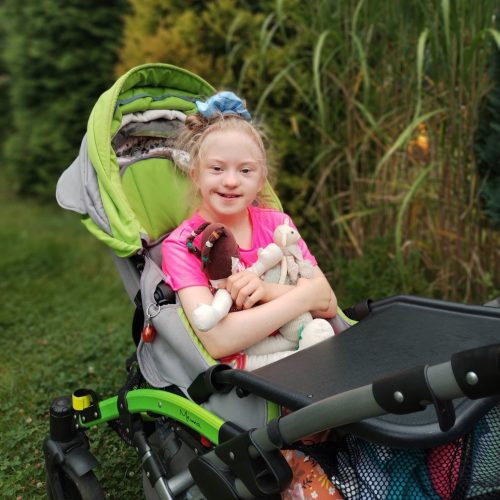 Holčička s Downovým syndromem na vozíku