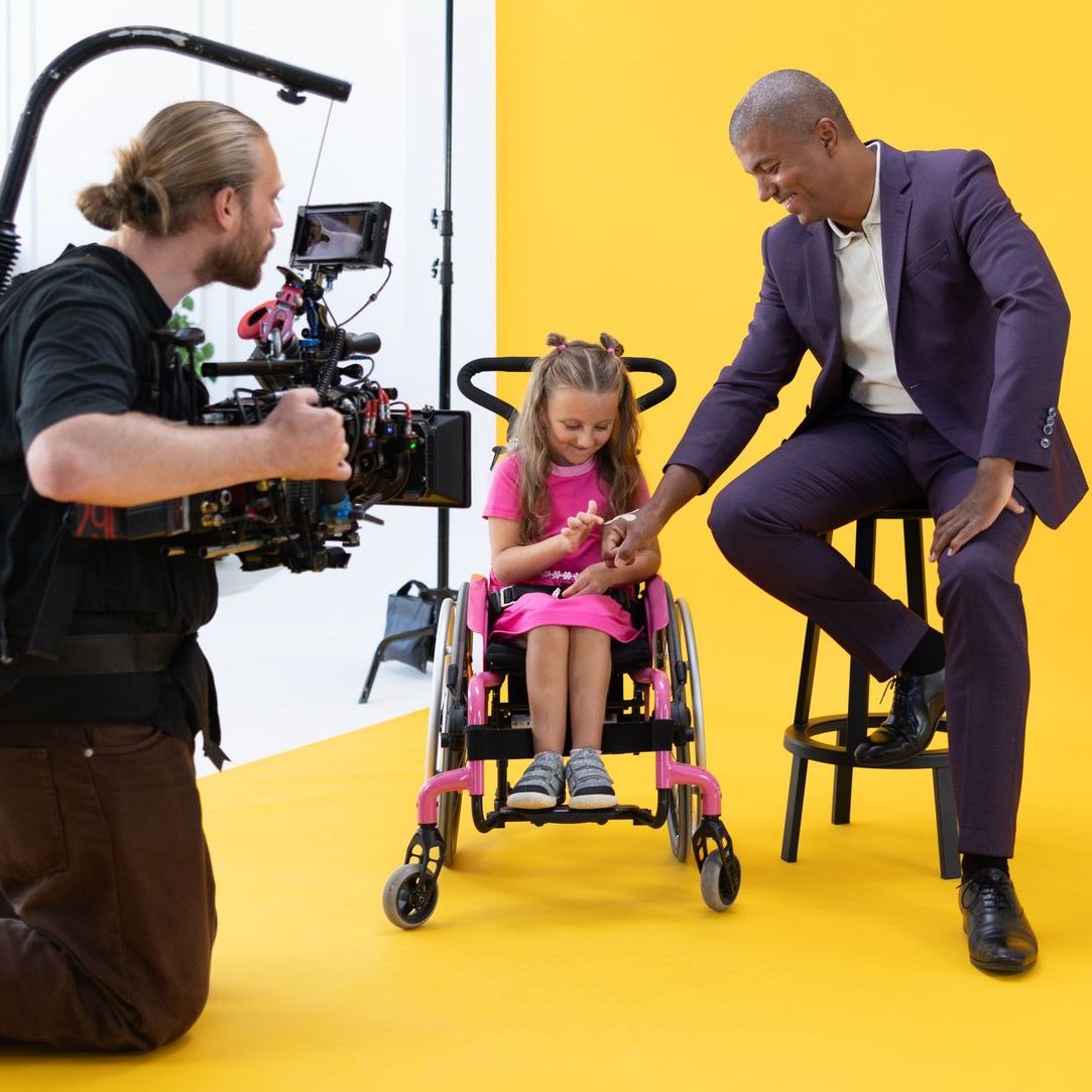 Zákulisí natáčení - kameraman zabírá Nikolku na vozíčku a Reye Korantenga