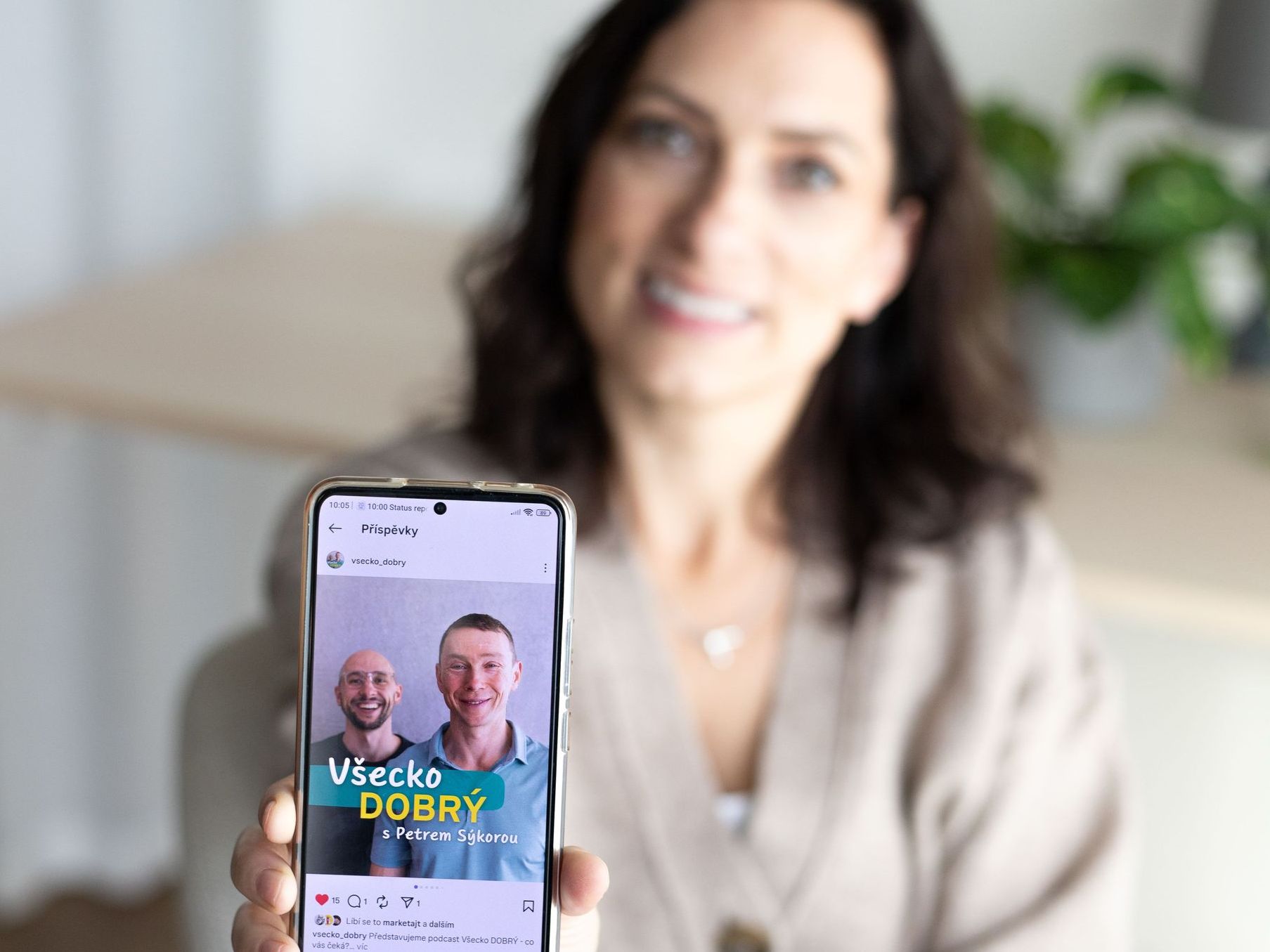 Zuzana Vítková s mobilem a vizuálem podcastu